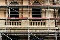 Exposed brick and stucco exterior wall during renovation. steel pipe scaffolding and metal stage