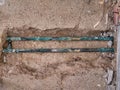 Exposed, leaking copper central heating pipes, badly corroded after being buried in the concrete floor slab of a house Royalty Free Stock Photo