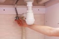 Exposed plastic plumbing attached to a copper joint with a shut-off valve under a white sink. Shut off the water supply to the sin Royalty Free Stock Photo