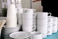 Exposed on stacks of white clean ceramic cups and saucers. Dishes in the restaurant for tea and coffee Royalty Free Stock Photo