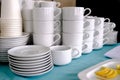Exposed on stacks of white clean ceramic cups and saucers. Dishes in the restaurant for tea and coffee Royalty Free Stock Photo
