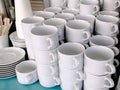 Exposed on stacks of white clean ceramic cups and saucers. Dishes in the restaurant for tea and coffee Royalty Free Stock Photo