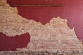 Exposed tan brick under red plaster wall with wood slat Royalty Free Stock Photo