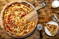 Exposition of fresh baked pizza on wooden plate, pizza with cheese, meat, mushrooms, red and yellow pepper, very tasty pizza.