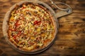 Exposition of fresh baked pizza on wooden plate, pizza with cheese, meat, mushrooms, red and yellow pepper, very tasty pizza.