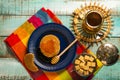 Exposition of fresh home made waffles with honey, caramel, on green wooden table.