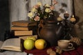 Exposition of hand made clay set on white wooden table, with books, candles, flowers, apple. Tea cup and clay kettle. Vintage styl Royalty Free Stock Photo