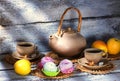 Exposition of hand made clay set on white wooden table and, with tasty chocolate cake. Tea cup and clay kettle. Royalty Free Stock Photo