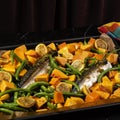 Exposition of healthy and tasty makerel with vegetbles on plate and black table. pumpkin, beans, lemon and makerel.