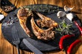 Exposition of mutton, fried lamb, barbecue lamb on wooden plate with chili pepper and garlic on wooden table. Royalty Free Stock Photo