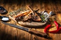 Exposition of mutton, fried lamb, barbecue lamb on wooden plate with chili pepper and garlic on wooden table. Royalty Free Stock Photo