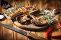 Exposition of mutton, fried lamb, barbecue lamb on wooden plate with chili pepper and garlic on wooden table. Royalty Free Stock Photo