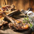 Exposition of mutton, fried lamb, barbecue lamb on wooden plate with chili pepper and garlic on wooden table. Royalty Free Stock Photo