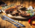 Exposition of mutton, fried lamb, barbecue lamb on wooden plate with chili pepper and garlic on wooden table. Royalty Free Stock Photo