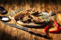 Exposition of mutton, fried lamb, barbecue lamb on wooden plate with chili pepper and garlic on wooden table. Royalty Free Stock Photo