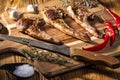 Exposition of mutton, fried lamb, barbecue lamb on wooden plate with chili pepper and garlic on wooden table. Royalty Free Stock Photo