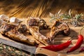 Exposition of mutton, fried lamb, barbecue lamb on wooden plate with chili pepper and garlic on wooden table. Royalty Free Stock Photo