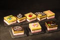Exposition of very taste and colorful marshmallow cake on rock table and black background, very tasty cheesecake.