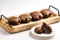 Exposition of very tasty chocolate cake with soft inside in wooden plate on white background,perfect desert with tea.