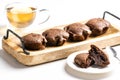 Exposition of very tasty chocolate cake with soft inside in wooden plate on white background,perfect desert with tea.