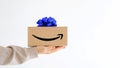 Express delivery Amazon. A young woman in sweatshirt holds a cardboard boxes with a blue bow. Online shopping Sale