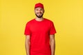 Express mail delivery, package transfer and logistics concept. Handsome friendly-looking courier in red uniform of Royalty Free Stock Photo