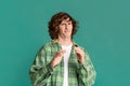 Expressing disgust. Millennial guy with curly hair feeling repulsed on color background Royalty Free Stock Photo