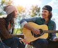 Expressing his love through his music. a young man playing his girlfriend a song on his guitar. Royalty Free Stock Photo