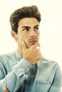 Expression of doubt or choice. Young man thinking. On white Royalty Free Stock Photo