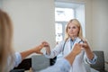 Doctor touching fingers of patient outstretched arms