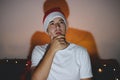 Expression of a thoughtful man over his business plan during the Christmas holidays. The face of a thinking man. Kid with white t- Royalty Free Stock Photo