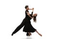 Two young graceful dancers wearing black stage outfits dancing ballroom dance isolated on white background. Concept of Royalty Free Stock Photo