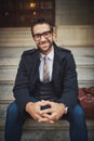 Expressions of style. Portrait of a stylish young man sitting on steps in the city. Royalty Free Stock Photo