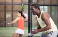 Expressive african american playing paddle ball on closed court