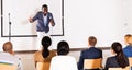 Expressive african american speaker with microphone on conference room stage Royalty Free Stock Photo