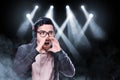 Expressive asian man in glasses wearing brown jacket enjoy the music with headphones