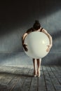 Expressive ballet dancer holding the big balloon in the studio