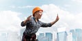 Expressive blonde woman in workwear and hardhat