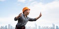 Expressive blonde woman in workwear and hardhat