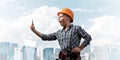 Expressive blonde woman in workwear and hardhat