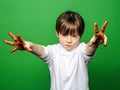 Expressive boy showing colorful hands after drawing