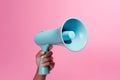 Expressive call Hand holding a blue megaphone on pink background