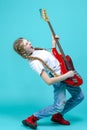 Expressive Caucasian Teenager Guitar Player With Red Shiny Bass Guitar Posing In Casual White Shirt Showing Pleased Expression On