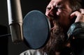 Expressive face closeup. Handsome man in recording studio. Music performance vocal. Singer singing song with a Royalty Free Stock Photo