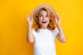 Expressive girl with surprised face. Young redhead woman in straw hat, surprised expression, isolated on yellow Royalty Free Stock Photo