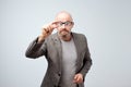 Funny middle aged man looking through glasses. His eyes are big.