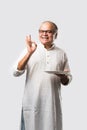 Expressive Indian Old man eating food from empty or blank white plate or bowl Royalty Free Stock Photo