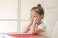 Expressive little girl sitting at the desk waiting Royalty Free Stock Photo