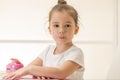 Expressive little girl sitting at the desk waiting