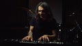 Satisfied man playing in dark hall. Smiling guy rehearsing in music studio.